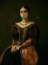 Medieval young woman as a duchess wearing protective mask against coronavirus spread