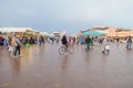 People walking around the old street market at Djemaa el-Fnaa square, Morocco.