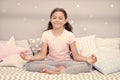 Meditate before go to bed. Girl child sit on bed in her bedroom. Kid prepare to go to bed. Pleasant time for evening Royalty Free Stock Photo