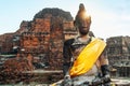 Meditating Buddha sculpture portrait in the middle day sun light rays on the old city brick wall ruins background in ancient