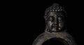 Meditating Buddha statuette isolated on black. Copy space. Royalty Free Stock Photo