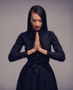 Meditating like a true warrior. Conceptual shot of a young female martial artist with her hands in prayer position.