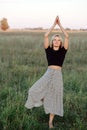 Meditating on one foot young blond woman exercising in a field