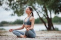 Meditating with sounds of nature. Brunette with nice body shape in sportive clothes have fitness day on a beach