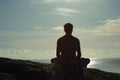 Meditating at Sunrise Overlooking Ocean Royalty Free Stock Photo