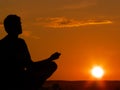 Meditating at sunset Royalty Free Stock Photo