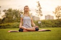 Meditating woman in the city park. Fit Girl relaxing on a yoga mat outdoor at sunset Royalty Free Stock Photo