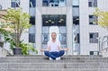 A meditating young man against the backdrop of a large business center Royalty Free Stock Photo