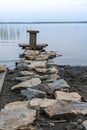 Meditation area on the lake, stone path and wooden seat, contemplating the sunset or daybreak