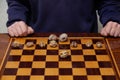 Walnuts lie on checkerboard. Behind chess player hands Royalty Free Stock Photo