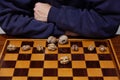 Walnuts lie on checkerboard. Behind chess player hands Royalty Free Stock Photo