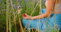 Meditation on flowers field. Woman relaxing. Lotus position. Breathing exercises. Royalty Free Stock Photo