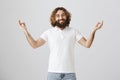 Meditation heals wounds in soul. Studio shot of calm and friendly easter bearded man spreading hands with zen gesture