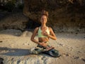 Meditation and pranayama. Caucasian woman sitting in Lotus pose, practicing breathing techniques. Yoga on the beach. Healthy Royalty Free Stock Photo