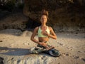 Meditation and pranayama. Caucasian woman sitting on the sand, practicing breathing techniques. Yoga on the beach. Healthy Royalty Free Stock Photo