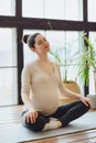 Meditation during pregnancy. Young calm tranquil pregnant woman doing yoga at home, meditating and practicing mindfulness, Royalty Free Stock Photo