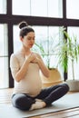 Meditation during pregnancy. Young calm tranquil pregnant woman doing yoga at home Royalty Free Stock Photo