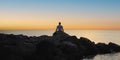 Meditation on the rocks, a man sitting on a rock in the sea at sunset Royalty Free Stock Photo