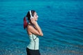 Meditation time and contemplation nature concept, copy space. Woman enjoying music in headset. Calm sea and fresh air.