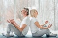 Meditation together. Senior couple doing yoga together in the white gym. Health and sport concept