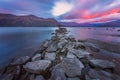 Meditation under the pink beauty of clouds movements over a stones jetty at dawn at Lake Wanaka in New Zealand Royalty Free Stock Photo