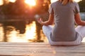 Meditation in yoga position near river - back view Royalty Free Stock Photo