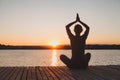 Meditation and yoga practice at sunset, silhouette of woman, calmness