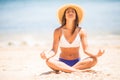 Meditation. Yoga woman meditating at serene beach. Girl relaxing in lotus pose in calm zen moment in the ocean water during yoga h Royalty Free Stock Photo