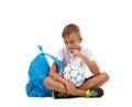 A meditative boy sitting on the ground in the lotus position. A kid with soccer ball isolated on a white background.