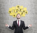 Meditative businessman is looking for new business ideas. Yellow stickers with the word ' idea' and sketches of ' light bulb