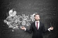 Meditative man is constructing a business flowchart which is drawn on the black wall behind.