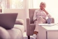 Meditative well-dressed senior lady chilling at home