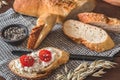 Mediterranean baguette with herbes and sel de mer, one slice with cream cheese and tomatoes