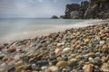 Mediterranean beach at slow motion speed long exposure - colorful pebbles and silky waves of blue sea on the shore. Texture Royalty Free Stock Photo