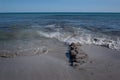 The Mediterranean coast with sand against a blue sky with a ruined jetty made of old stones, some of which protrudes from the Royalty Free Stock Photo