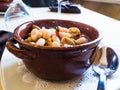 Mediterranean cooking, delicious baked bean and chestnut soup in an earthenware bowl in an Italian restaurant Royalty Free Stock Photo