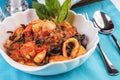 Black pasta with shrimps, crab meat, seafood, squid rings, basil, greens and cheese. Royalty Free Stock Photo