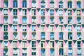 Mediterranean facade in Barcelona with pink wall and geometric balconies and windows in a textured distribution. Royalty Free Stock Photo