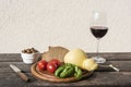 Mediterranean food on a wooden plate - cheese, olives, tomatoes, bread and wine, Sardinia, Italy