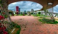 Park with round and metalic parts over red tiling with towers on the background fira barcelon