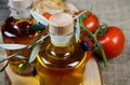 Mediterranean italian healthy food concept: isolated close up of olive oil bottles on wood cutting board with twig and red Royalty Free Stock Photo