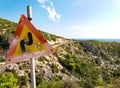 Mediterranean landscape with a road and a shooted traffic sign Royalty Free Stock Photo