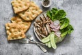 Mediterranean lunch - crispy italian focaccia, grilled turkey, green romaine salad and fresh vegetables on a grey background, top