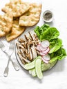 Mediterranean lunch - crispy italian focaccia, grilled turkey, green romaine salad and fresh vegetables on a light background, top