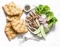 Mediterranean lunch - crispy italian focaccia, grilled turkey, green romaine salad and fresh vegetables on a light background, top