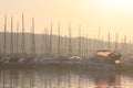 Mediterranean marina with sailing and motor yachts in the rays of the morning dawn. Sea touristic business. Infrastructure of the