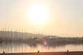 Mediterranean marina with sailing and motor yachts in the rays of the morning dawn. Sea touristic business. Infrastructure of the