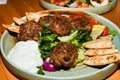 Mediterranean meatballs with salad, chickpeas with tomato sauce, yogurt dip and pita bread