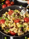 Mediterranean pasta salad bowl with a fork on dark background Royalty Free Stock Photo