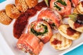 Mediterranean salmon rolls with cheese and greens in chili sauce, served with pancakes and buns Royalty Free Stock Photo